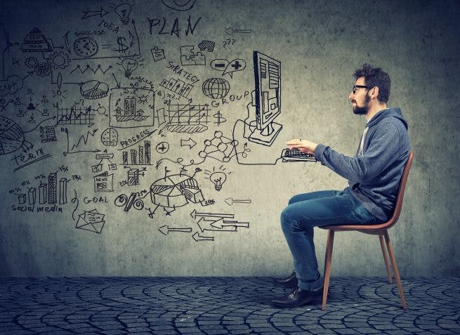 man typing on a computer that is drawn on the wall behind him