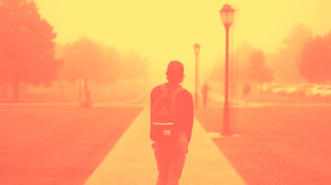 orange tinted photo of man on campus